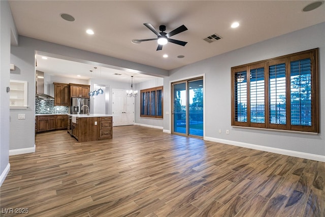 7416 Redhead Dr, North Las Vegas, NV 89084 - unfurnished living room featuring a chandelier, a ceiling fan, dark wood-style floors, and recessed lighting
