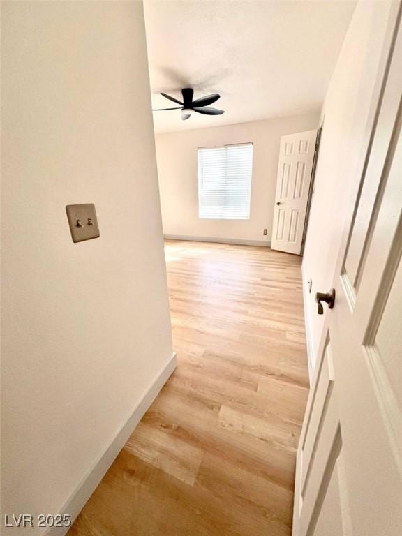 hall with baseboards and light wood-style flooring