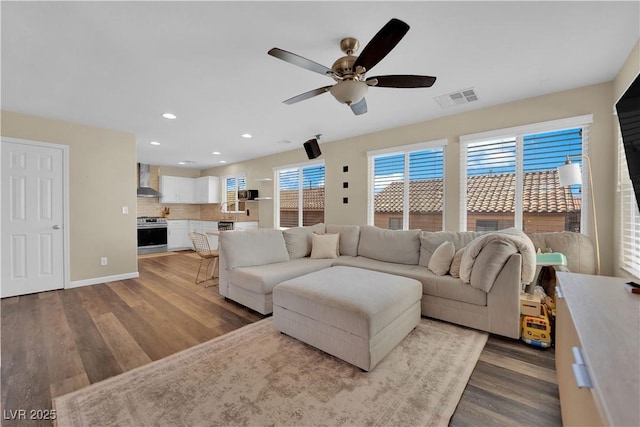 living room with a ceiling fan, wood finished floors, recessed lighting, and visible vents