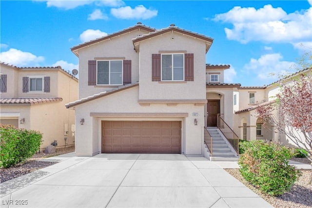 mediterranean / spanish-style home featuring a tile roof, concrete driveway, stucco siding, and an attached garage