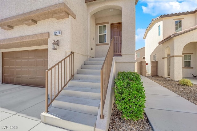 doorway to property with stucco siding and a garage