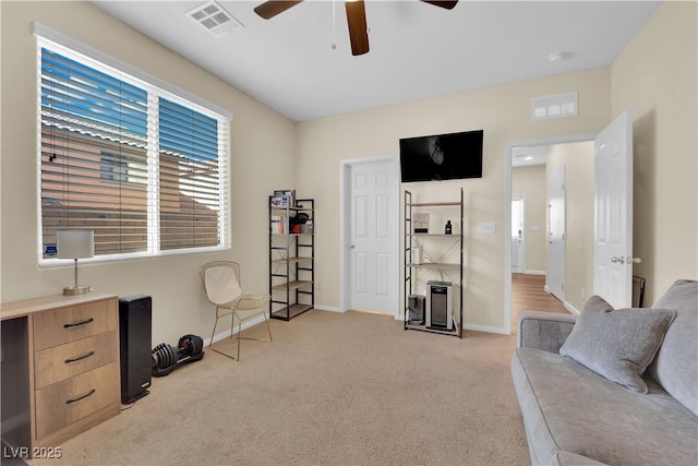 sitting room with a ceiling fan, baseboards, light colored carpet, and visible vents