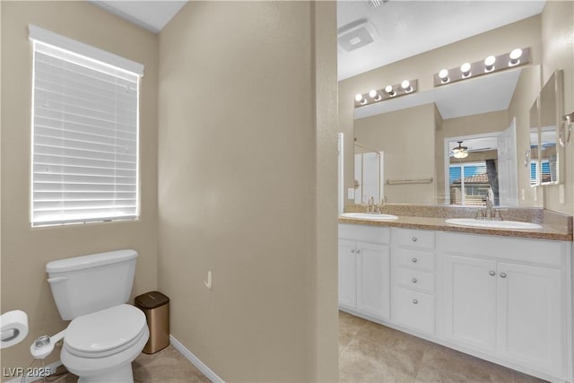 bathroom with double vanity, toilet, ceiling fan, and a sink