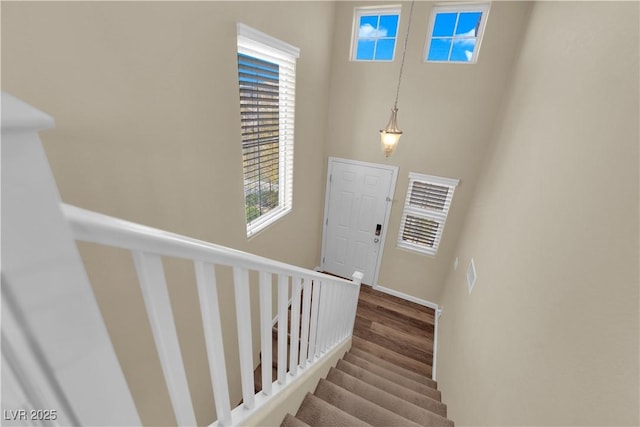 staircase with baseboards and wood finished floors