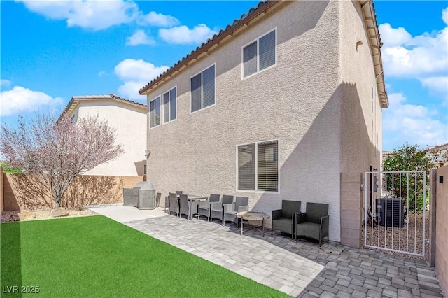 rear view of property with stucco siding, fence, a patio, a tiled roof, and a yard