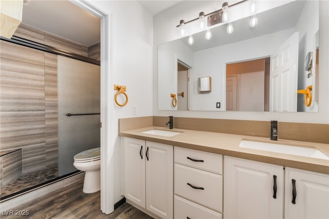 5217 Cold River Ave, Las Vegas, NV 89130 - bathroom featuring tiled shower, double vanity, and wood finished floors