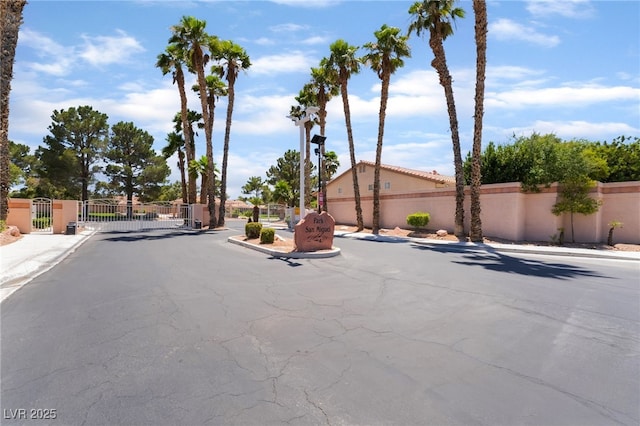 5217 Cold River Ave, Las Vegas, NV 89130 - view of asphalt road featuring sidewalks, a gate, curbs, and a gated entry