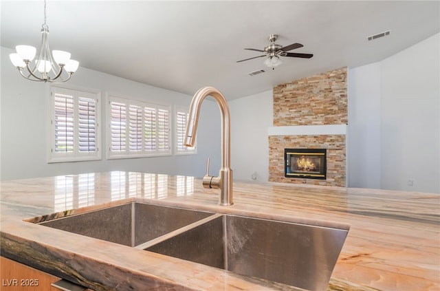 5217 Cold River Ave, Las Vegas, NV 89130 - kitchen with lofted ceiling, ceiling fan, open floor plan, a chandelier, and a stone fireplace