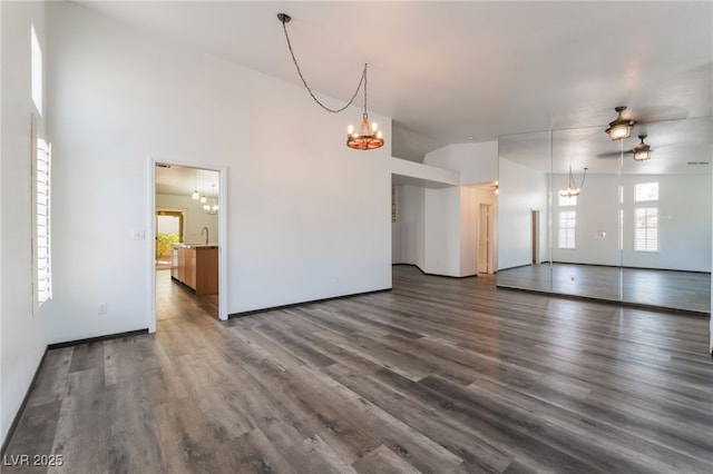 5217 Cold River Ave, Las Vegas, NV 89130 - unfurnished living room featuring a chandelier, healthy amount of natural light, and wood finished floors