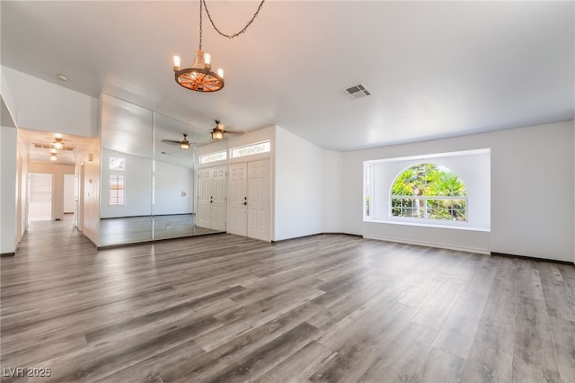 5217 Cold River Ave, Las Vegas, NV 89130 - unfurnished living room with a chandelier, plenty of natural light, a ceiling fan, and wood finished floors