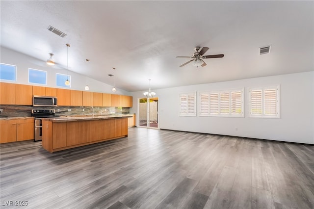 5217 Cold River Ave, Las Vegas, NV 89130 - kitchen with stainless steel appliances, vaulted ceiling, open floor plan, backsplash, and a center island