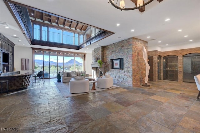 15 Rue Du Rivoli Pl, Henderson, NV 89011 - living area featuring stone tile floors, a high ceiling, recessed lighting, and a stone fireplace