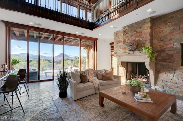 15 Rue Du Rivoli Pl, Henderson, NV 89011 - living area featuring a towering ceiling, healthy amount of natural light, a fireplace, a mountain view, and stone finish floors