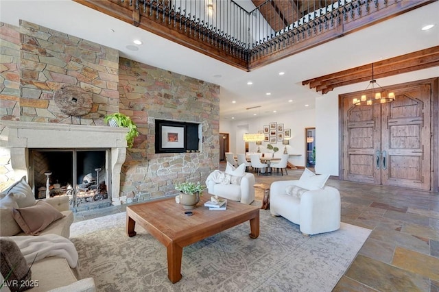 15 Rue Du Rivoli Pl, Henderson, NV 89011 - living area with stone finish flooring, a chandelier, a glass covered fireplace, a towering ceiling, and recessed lighting