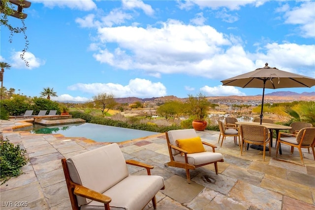 15 Rue Du Rivoli Pl, Henderson, NV 89011 - view of swimming pool featuring a mountain view, a patio, outdoor dining space, and an infinity pool
