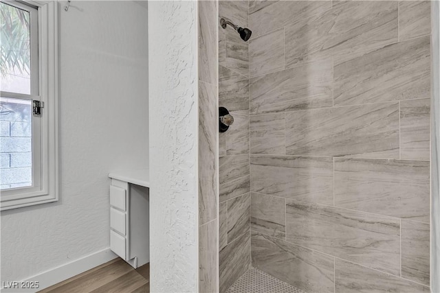 2204 Monterey Ave, Las Vegas, NV 89104 - bathroom featuring a tile shower, baseboards, and wood finished floors