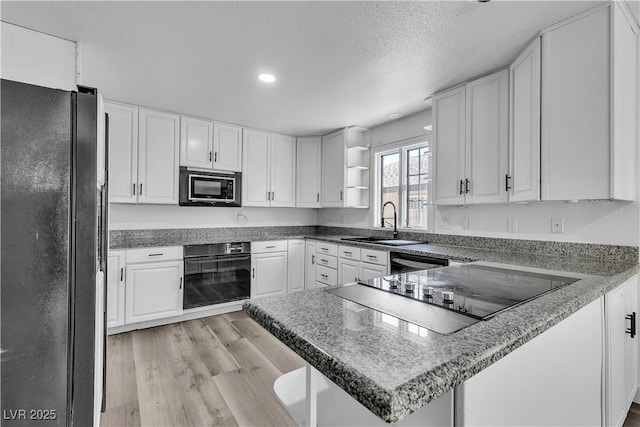 2204 Monterey Ave, Las Vegas, NV 89104 - kitchen with black appliances, a sink, a peninsula, open shelves, and white cabinets