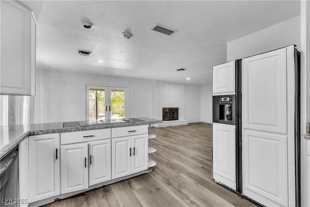 2204 Monterey Ave, Las Vegas, NV 89104 - kitchen featuring paneled refrigerator with ice dispenser, white cabinets, light wood finished floors, open floor plan, and a fireplace