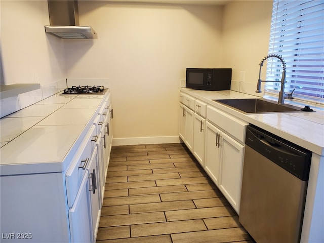 3168 S Eastern Ave Unit 45, Las Vegas, NV 89169 - kitchen with appliances with stainless steel finishes, wall chimney range hood, a sink, white cabinetry, and light wood-type flooring