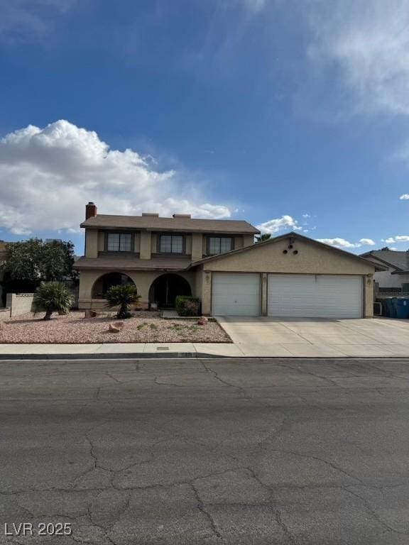 6801 Atwood Ave, Las Vegas, NV 89108 - view of front of home featuring stucco siding, driveway, a garage, and a chimney