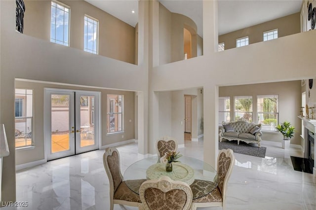 10550 Patrington Ct, Las Vegas, NV 89183 - dining room with a high ceiling, marble finish floor, french doors, baseboards, and a glass covered fireplace