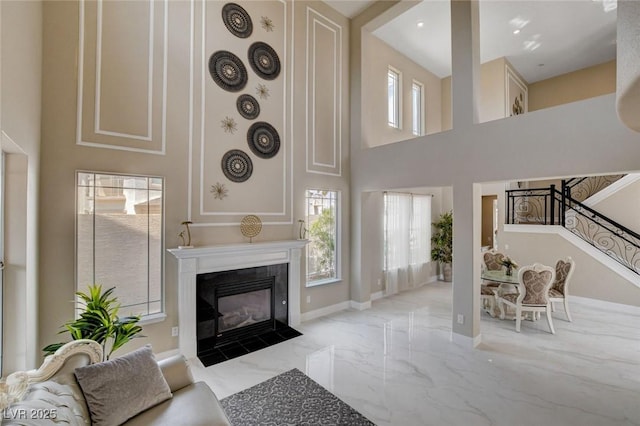 10550 Patrington Ct, Las Vegas, NV 89183 - living area with stairway, marble finish floor, a towering ceiling, baseboards, and a fireplace