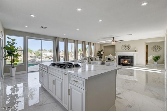 10550 Patrington Ct, Las Vegas, NV 89183 - kitchen featuring stainless steel gas cooktop, marble finish floor, a wealth of natural light, and ceiling fan