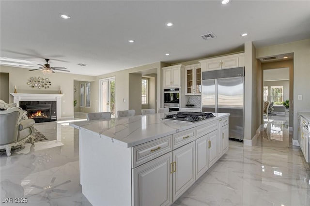 10550 Patrington Ct, Las Vegas, NV 89183 - kitchen with a ceiling fan, marble finish floor, white cabinetry, appliances with stainless steel finishes, and visible vents