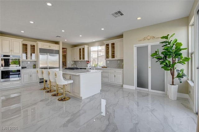 10550 Patrington Ct, Las Vegas, NV 89183 - kitchen with stainless steel appliances, light countertops, visible vents, and tasteful backsplash