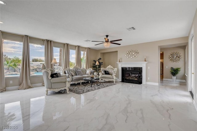 10550 Patrington Ct, Las Vegas, NV 89183 - living area with visible vents, baseboards, a premium fireplace, a ceiling fan, and marble finish floor