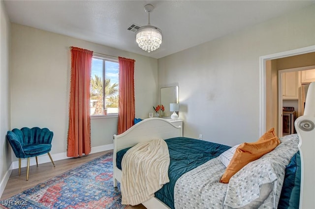 10550 Patrington Ct, Las Vegas, NV 89183 - bedroom featuring an inviting chandelier, wood finished floors, visible vents, and baseboards