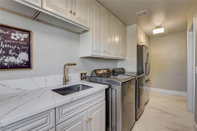 10550 Patrington Ct, Las Vegas, NV 89183 - laundry room featuring washing machine and clothes dryer, a sink, visible vents, marble finish floor, and cabinet space