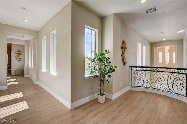 10550 Patrington Ct, Las Vegas, NV 89183 - corridor featuring light wood-style flooring, visible vents, and a wealth of natural light
