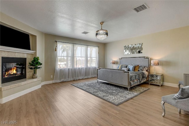 10550 Patrington Ct, Las Vegas, NV 89183 - bedroom with a tile fireplace, wood finished floors, visible vents, and baseboards