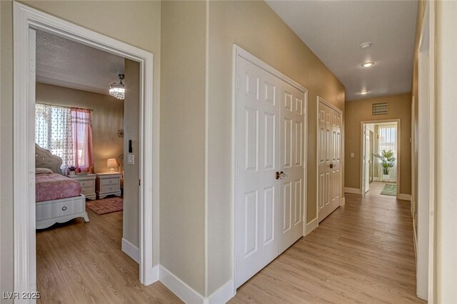 10550 Patrington Ct, Las Vegas, NV 89183 - hall with baseboards, visible vents, and light wood-style floors