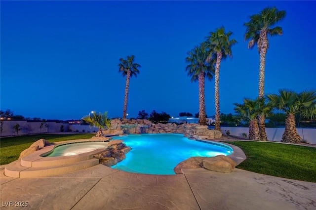10550 Patrington Ct, Las Vegas, NV 89183 - pool at night with a pool with connected hot tub, a lawn, a patio, and fence