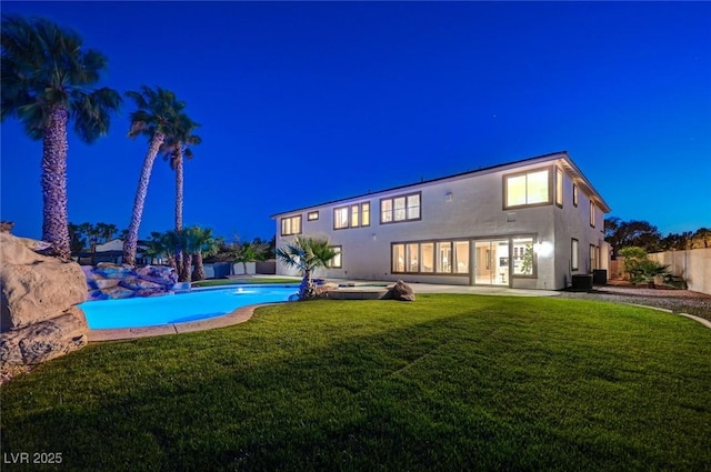 10550 Patrington Ct, Las Vegas, NV 89183 - pool at night with a patio area, a lawn, a fenced backyard, and an outdoor pool