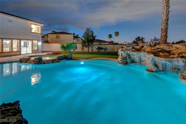 10550 Patrington Ct, Las Vegas, NV 89183 - pool at dusk featuring a pool with connected hot tub and fence