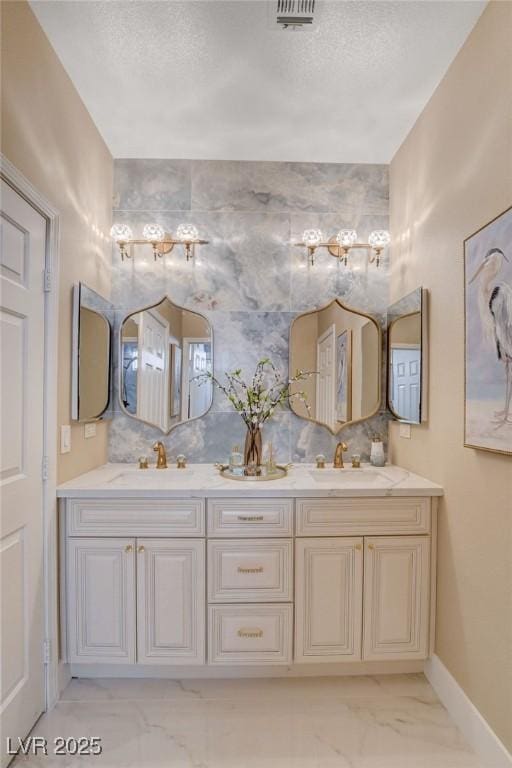10550 Patrington Ct, Las Vegas, NV 89183 - bathroom featuring double vanity, marble finish floor, baseboards, and a sink