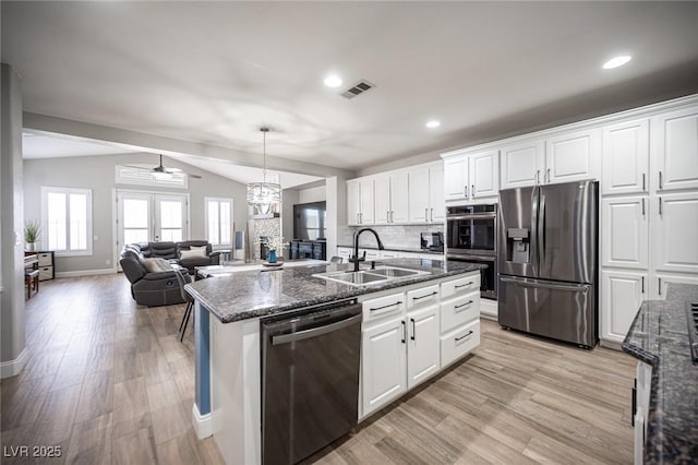 5815 Pristine Falls Ave, Las Vegas, NV 89131 - kitchen with appliances with stainless steel finishes, a sink, light wood-style flooring, vaulted ceiling, and open floor plan