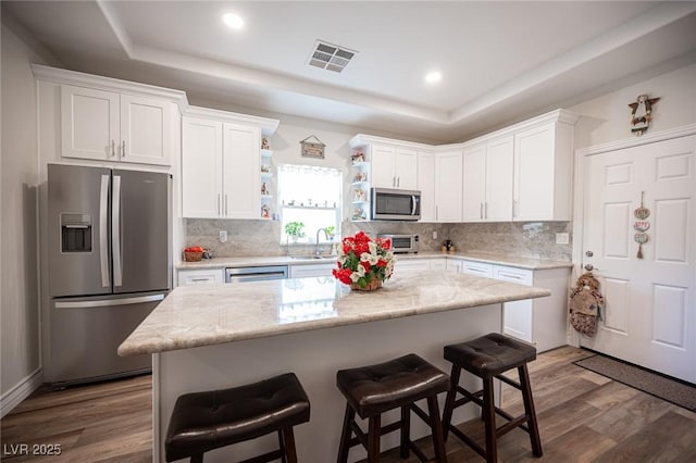 5815 Pristine Falls Ave, Las Vegas, NV 89131 - kitchen featuring stainless steel appliances, a tray ceiling, open shelves, white cabinets, and dark wood-style floors