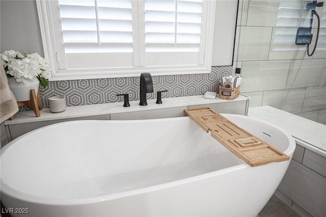 5815 Pristine Falls Ave, Las Vegas, NV 89131 - bathroom featuring a freestanding bath, backsplash, and a sink