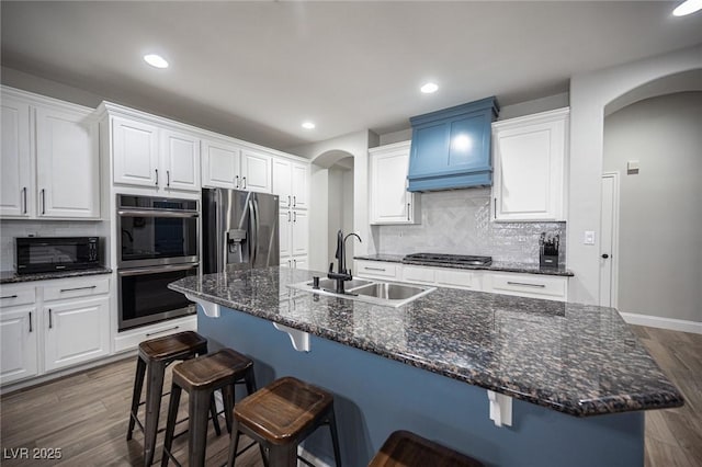 5815 Pristine Falls Ave, Las Vegas, NV 89131 - kitchen featuring appliances with stainless steel finishes, a sink, arched walkways, white cabinetry, and recessed lighting