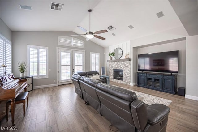 5815 Pristine Falls Ave, Las Vegas, NV 89131 - living area with a ceiling fan, wood finished floors, baseboards, a stone fireplace, and vaulted ceiling