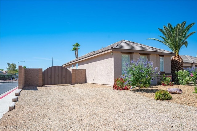 5815 Pristine Falls Ave, Las Vegas, NV 89131 - view of home's exterior with a gate, stucco siding, and a tiled roof