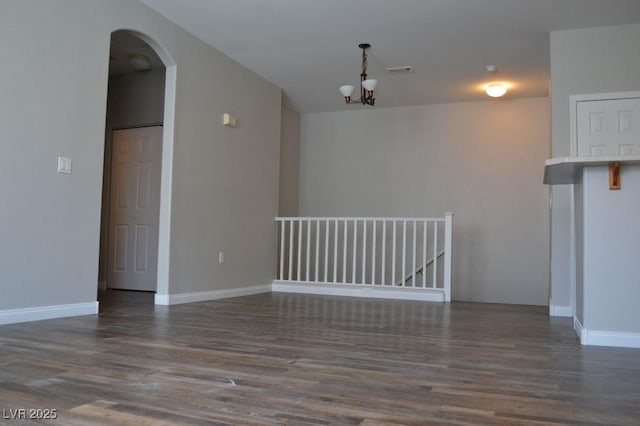 9303 Gilcrease Ave Unit 1097, Las Vegas, NV 89149 - spare room featuring baseboards, wood finished floors, arched walkways, and a notable chandelier