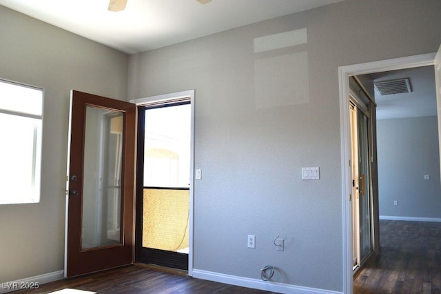 9303 Gilcrease Ave Unit 1097, Las Vegas, NV 89149 - unfurnished room featuring dark wood-type flooring, a healthy amount of sunlight, baseboards, and visible vents