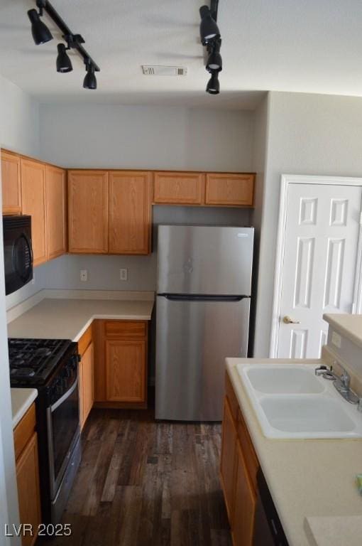 9303 Gilcrease Ave Unit 1097, Las Vegas, NV 89149 - kitchen with light countertops, track lighting, a sink, appliances with stainless steel finishes, and dark wood-style flooring