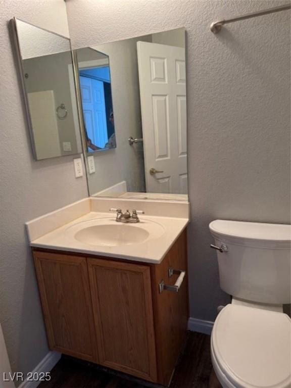 9303 Gilcrease Ave Unit 1097, Las Vegas, NV 89149 - half bathroom featuring wood finished floors, baseboards, vanity, and toilet