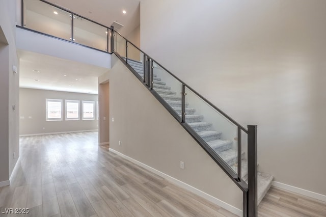 staircase featuring baseboards and wood finished floors